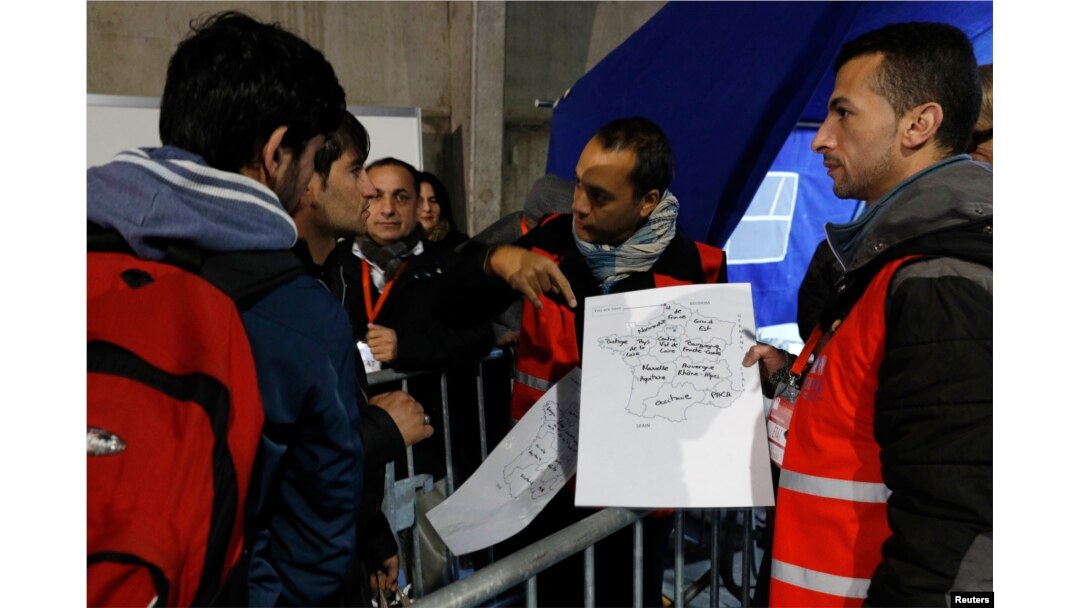 Migrants look at a map of France at a processing center to be registered on the second day of their evacuation and transfer to reception centers in France, during the dismantlement of the camp called "the jungle" in Calais, France, Oct. 25, 2016.