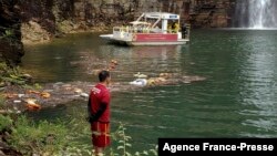 This handout picture released by Minas Gerais Fire Department shows a firefighter during a rescue operation after a large rock fragment broke off a ravine and plunged onto several tourist boats, at the canyons of Furnas Lake, city of Capitolio, Minas Gera