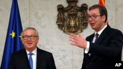 European Commission President Jean-Claude Juncker, left, speaks with Serbia's President Aleksandar Vucic in Belgrade, Serbia, Feb. 26, 2018.