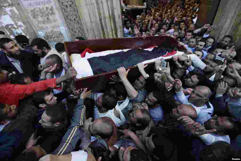 Supporters of the Muslim Brotherhood and Egyptian President Mohamed Morsi carry a body of one of six victims killed during Wednesday's clashes, Al Azhar mosque, Cairo, Egypt, December 7, 2012. 