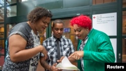 FILE - A man shows family members his new documents after changing his officially registered gender from female to male, in Amsterdam July 1, 2014. 