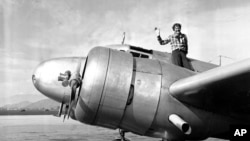 FILE - American aviator Amelia Earhart waves from the Electra before taking off from Los Angeles, California, March 10, 1937.