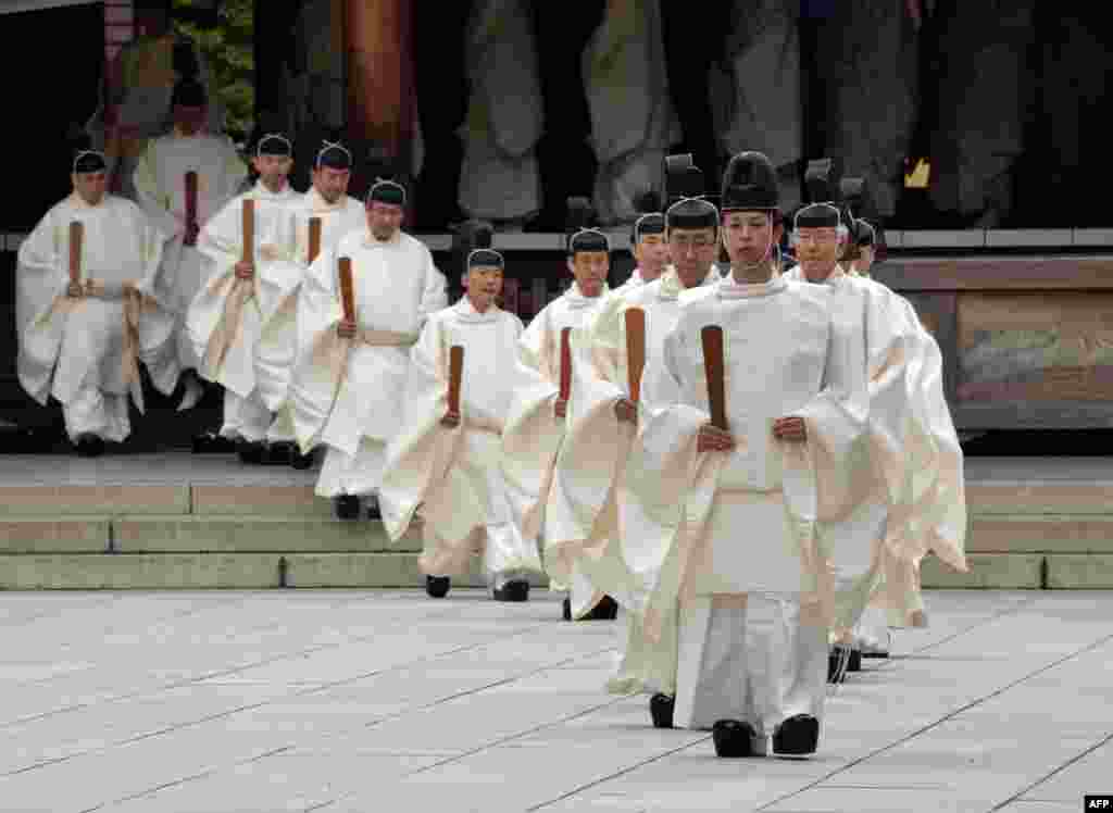 Shinto priests walk out from the outer shrine after they administer a Shinto rite "Kiyoharai" on the first day of the four-day autumn festival at the Yasukuni shrine in Tokyo, Japan. 