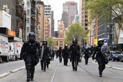 Polisi anti huru hara bersiap membubarkan pengunjuk rasa yang menentang mandat terkait COVID-19 bagi industri konstruksi di Melbourne, Australia, 22 September 2021.