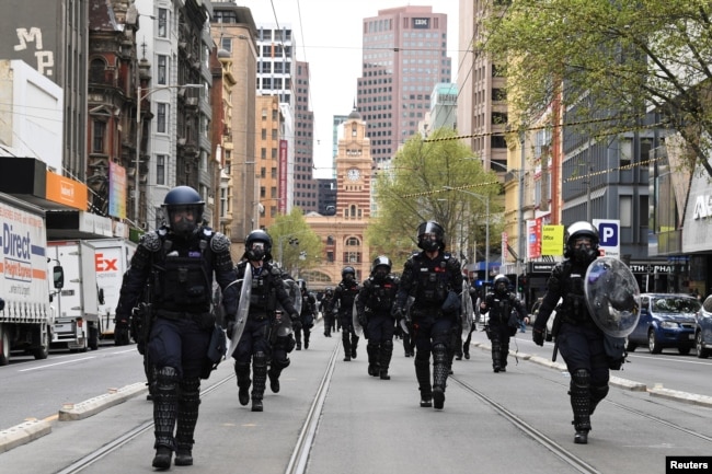 Polisi anti huru hara bersiap membubarkan pengunjuk rasa yang menentang mandat terkait COVID-19 bagi industri konstruksi di Melbourne, Australia, 22 September 2021.