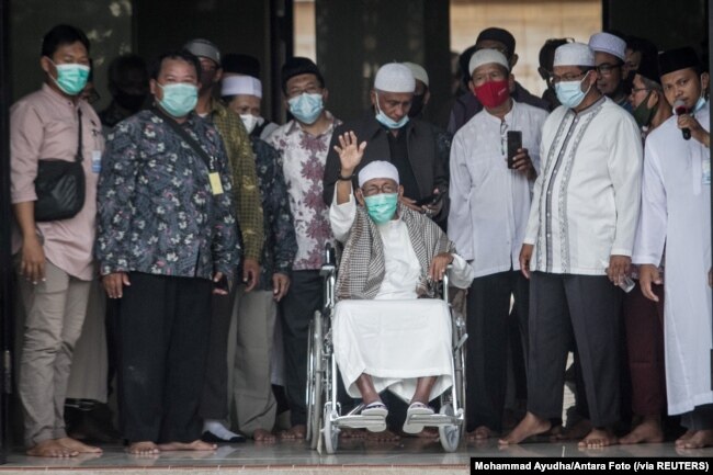 Abu Bakar Ba'asyir melambaikan tangan setibanya di Pondok Pesantren Al Mukmin Ngruki, setelah bebas murni, di Sukoharjo, Solo, Jumat, 8 Januari 2021. (Foto: Mohammad Ayudha/Antara Foto via Reuters)