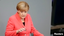 German Chancellor Angela Merkel gestures as she delivers the government's declaration on current refugee crisis at the lower house of parliament Bundestag in Berlin, Sept. 24, 2015.