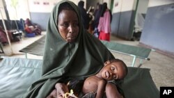 Mama akiwa na mtoto wake mwenye utapiamlo kwenye hospitali ya Banadir mjini Mogadishu nchini Somalia, Julai 7, 2011