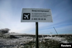 Sebuah tanda bertuliskan "Tidak boleh masuk! Mungkin ada sisa-sisa korban kecelakaan penerbangan MH17 di wilayah itu" terlihat di lokasi jatuhnya pesawat Boeing 777 Malaysia Airlines di dekat desa Hrabove (Grabovo) di wilayah Donetsk, 15 Desember. 2014. (Foto: Reuters)