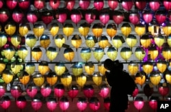 A woman prays in front of a wall of lanterns to celebrate the New Year at the Jogyesa Buddhist temple in Seoul, South Korea, Monday, Dec. 31, 2018. (AP Photo/Ahn Young-joon)