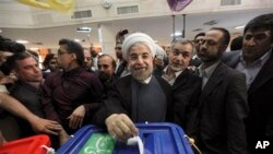 အီရန်သမ္မတကိုယ်စားလှယ်လောင်း Hasan Rowhani မဲပေးနေစဉ်။ (ဇွန်လ ၁၄ ရက်၊ ၂၀၁၃)။