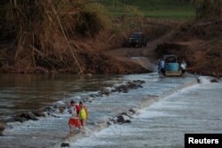 Local residents cross a river using a cable after Hurricane Maria destroyed the town's bridge in San Lorenzo, Morovis, Puerto Rico, Oct. 4, 2017.