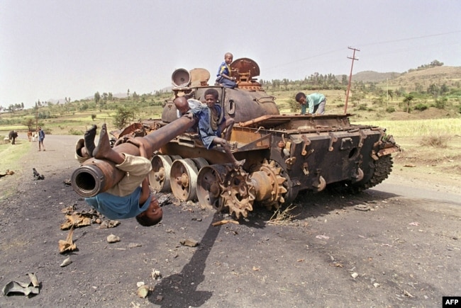 FILE - Eritrean children play on an Ethiopian army tank, June 7, 1991. The tank was destroyed by Eritrean Liberation Front (EPLF) rebels in the battle for Amara, capital of Eritrea, that fell days earlier to EPLF rebels after 17 years of war.