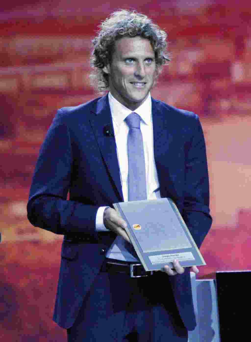 Diego Forlán, delantero del Atlético de Madrid, muestra su trofeo al mejor jugador de la Copa de Europa 2009-2010.