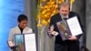 Nobel Peace Prize winners Dmitry Muratov from Russia and Maria Ressa of the Philippines pose with their awards during the Nobel Peace Prize ceremony at Oslo City Hall, Norway, Dec. 10, 2021.