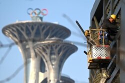 Seorang pria bekerja di dekat Menara Olimpiade di Beijing, 4 Januari 2022. Beijing akan menjadi tuan rumah Olimpiade Musim Dingin 2022, yang akam dimulai 4 Februari 2022 mendatang. (Noel Celis / AFP)