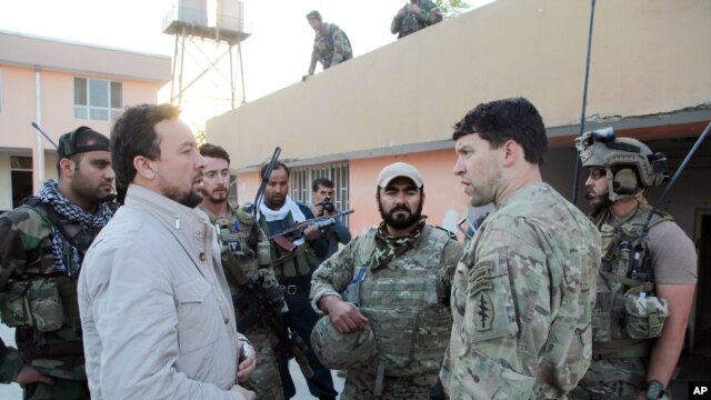 El jefe de la policía de Kunduz, Mohammad Qasim Jangalbagh, izquierda, conversa con fuerzas especiales de Afganistán y Estados Unidos.