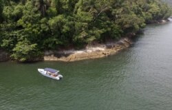 A boat belonging to Animal Heart Protectors is anchored off Furtada Island, popularly known as “Island of the Cats,” where they deliver food and water to the cats in Mangaratiba, Brazil, Tuesday, Oct. 13, 2020. (AP Photo/Mario Lobao)