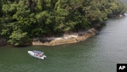 A boat belonging to Animal Heart Protectors is anchored off Furtada Island, popularly known as “Island of the Cats,” where they deliver food and water to the cats in Mangaratiba, Brazil, Tuesday, Oct. 13, 2020. (AP Photo/Mario Lobao)