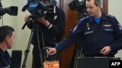 A Russian military official points to the flight recorder from the Russian Sukhoi Su-24 bomber that was shot down by a Turkish jet on Nov. 24, during a briefing on decoding the black boxes, Moscow, Dec. 18, 2015.