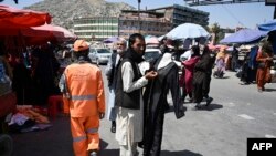 Orang-orang berjalan di sepanjang pasar di pusat kota Kabul pada 28 Agustus 2021, setelah militer Taliban mengambil alih Afghanistan. (Foto: AFP/Aamir Qureshi)