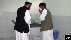Afghans stand by bodies of people killed in a bombing in a mosque in Taloqan, north of Kabul Afghanistan, 08 Oct 2010