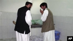 Afghans stand by bodies of people killed in a bombing in a mosque in Taloqan, north of Kabul Afghanistan, 08 Oct 2010