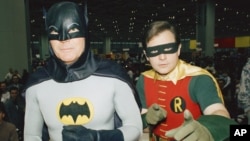 FILE - Actors Adam West, left, and Burt Ward, dressed as their characters Batman and Robin, pose for a photo at the "World of Wheels" custom car show in Chicago, Jan. 27, 1989.