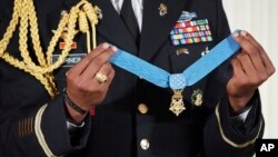 FILE - A military aide holds up the nation's highest military honor, the Medal of Honor, during a ceremony in the East Room of the White House in Washington, Oct. 23, 2017.