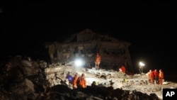 Rescue workers work to save people trapped under debris after an earthquake in Ercis, near the eastern Turkish city of Van, October 25, 2011.