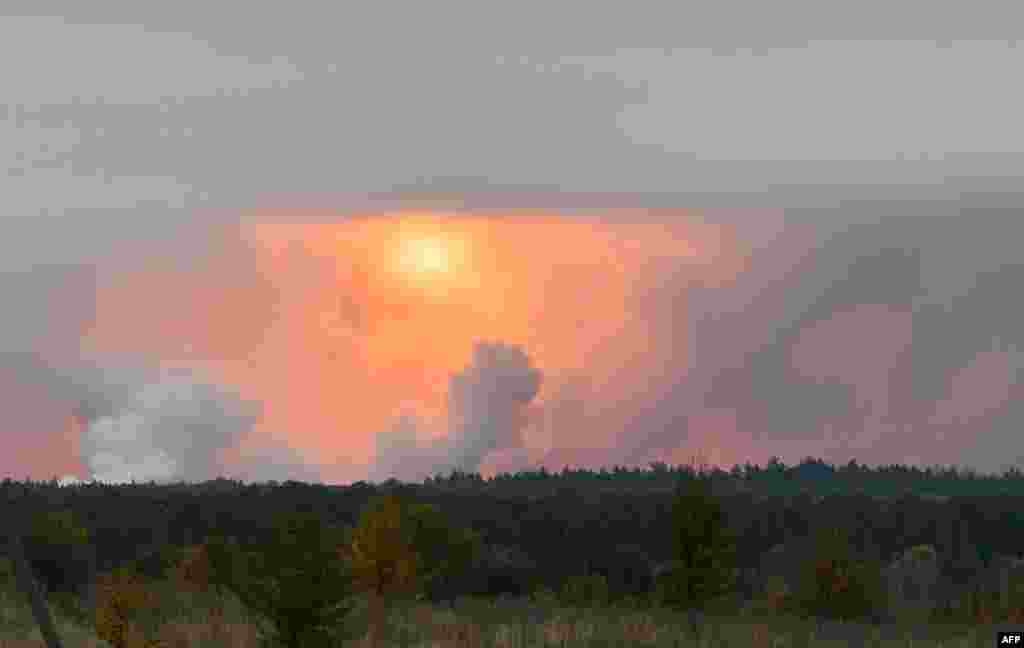 A fire ball is seen in the sky from the village Zaudaika, about 8 kilometers away from the site of a series of explosions at an ammunition storage center in Ukraine&rsquo;s northern Chernihiv region.