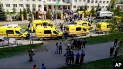 Ambulans dan truk polisi diparkir di sebuah sekolah setelah penembakan, di Kazan, Rusia, Selasa, 11 Mei 2021. Media Rusia melaporkan bahwa beberapa orang telah tewas dan terluka dalam penembakan di sekolah tersebut. (AP Photo)
