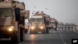FILE - In this Emirates News Agency photo, UAE military vehicles and personnel travel from Al Hamra Military Base to Zayed Military City, an Emerati base, marking the return of the first batch of UAE military personnel from Yemen, Nov. 7, 2015.