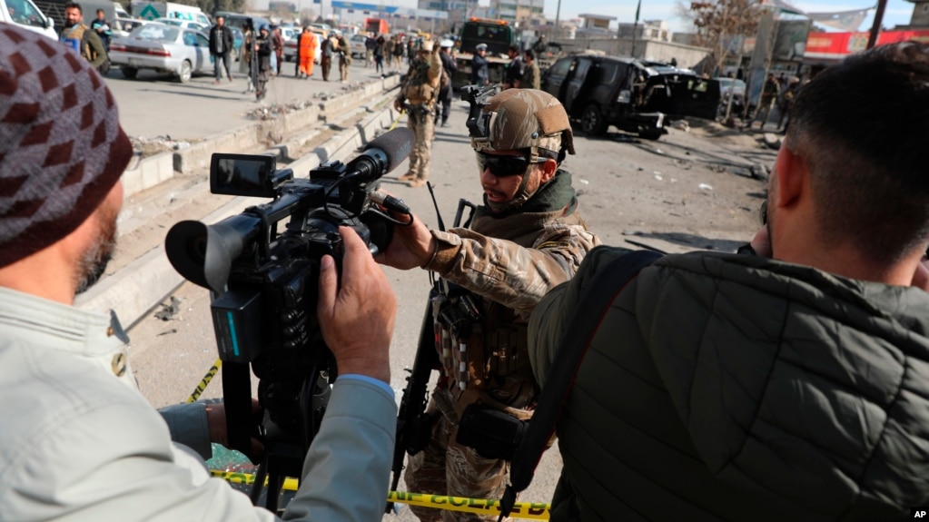 Polisi keamanan Afghanistan memblokir seorang jurnalis TV dari syuting di lokasi serangan bom di Kabul, Afghanistan, 10 Februari 2021. (Foto: AP)