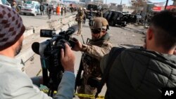 Polisi keamanan Afghanistan memblokir seorang jurnalis TV dari syuting di lokasi serangan bom di Kabul, Afghanistan, 10 Februari 2021. (Foto: AP)