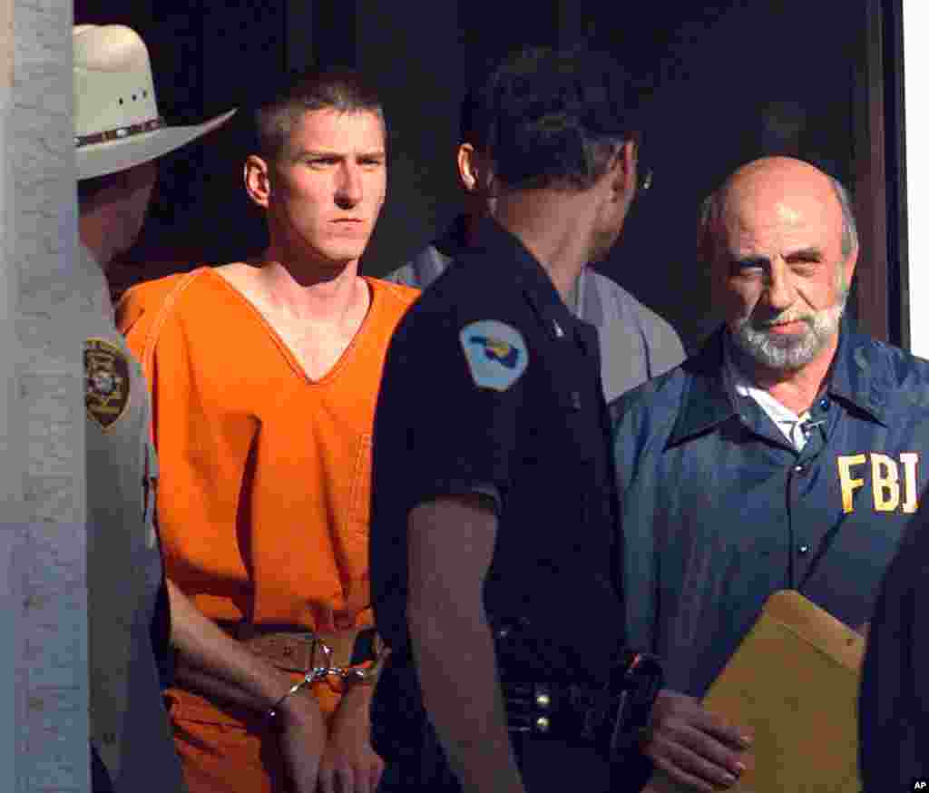 FILE - In this April 21, 1995 file photo, Timothy James McVeigh is lead out of the Noble County Courthouse by state and federal law enforcement officials in Perry, Okla., after being identified as a suspect in the bombing of the Oklahoma City Federal buil