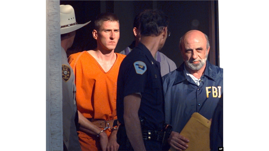FILE - In this April 21, 1995 file photo, Timothy McVeigh is led out of the Noble County Courthouse by state and federal law enforcement officials in Perry, Oklahoma, after being identified as a suspect in the bombing of the Oklahoma City Federal building. McVeigh was eventually convicted of the bombing and executed.