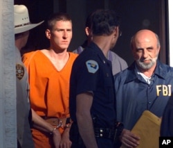 FILE - In this April 21, 1995 file photo, Timothy McVeigh is led out of the Noble County Courthouse by state and federal law enforcement officials in Perry, Oklahoma, after being identified as a suspect in the bombing of the Oklahoma City Federal building. McVeigh was eventually convicted of the bombing and executed.