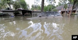 FILE - A car is submerged in floodwaters in the aftermath of Hurricane Harvey near the Addicks and Barker Reservoirs in Houston, Sept. 4, 2017.