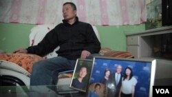 中國著名維權律師高智晟2015年在陝西的窯洞住宅裡聽記者講話，旁邊是他兒子的照片和女兒與美國前總統布殊的合影。