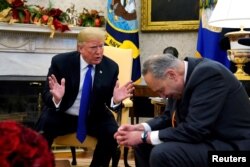 President Donald Trump speaks with Senate Democratic Leader Chuck Schumer in the Oval Office in Washington, Dec. 11, 2018. At the meeting, Trump said he would “proudly” accept responsibility for a partial U.S. government shutdown if Congress does not pass legislation that includes funding for his proposed border wall.