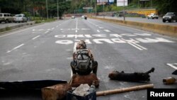 Un membre de l'opposition bloque la route à Caracas, Vénézuela, le 30 juillet 2017.