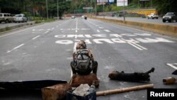 Un membre de l'opposition bloque la route à Caracas, Vénézuela, le 30 juillet 2017. 