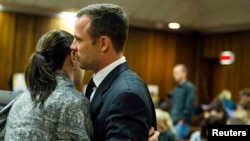 Oscar Pistorius habla con su hermana Aimee durante el quinto día del juicio por el asesinato de su novia.
