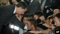 Spanish Prince Felipe, left consoles family members of the victims of the earthquake in Lorca, Spain, May 13, 2011