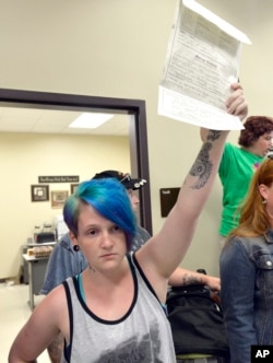 Lexie Colon holds up her marriage certificate at the Rowan County Courthouse in Morehead, Ky., Sept. 1, 2015. Signed by clerk Kim Davis, it certifies her marriage to Camryn Colon, a transgender male.