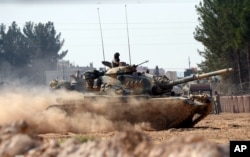 FILE - Turkish tanks head toward the Syrian border, in Karkamis, Turkey, Aug. 31, 2016.