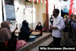 Presiden Joko Widodo berbincang dengan para warga dalam kunjungannya ke Tarakan, Kalimantan Utara, pada 19 Oktober 2021, untuk mengecek program vaksinasi di wilayah tersebut. (Foto: Reuters/Willy Kurniawan)