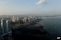 The setting sun lights up the Panama City skyline, Monday, April 4, 2016.