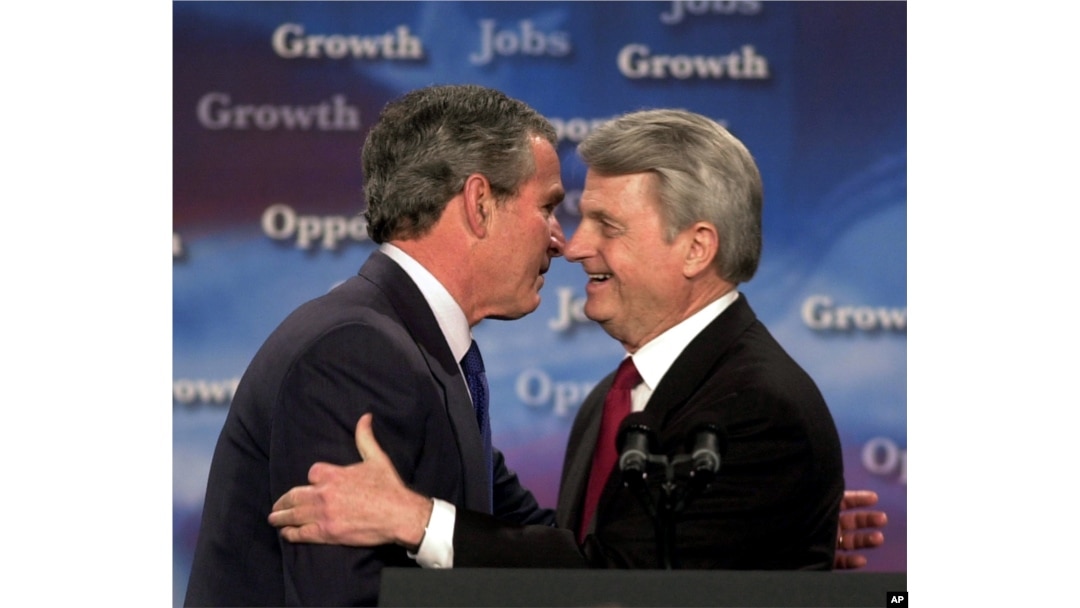 President George Bush, left, and U.S. Sen. Zell Miller, D-Ga., embrace as Bush is introduced at a program on Jobs and Economic Growth at Harrison High School in Kennesaw, Georgia, Feb. 20, 2003.